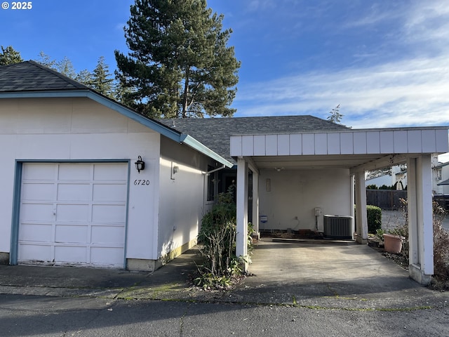 view of front of property with a carport, a garage, and central air condition unit