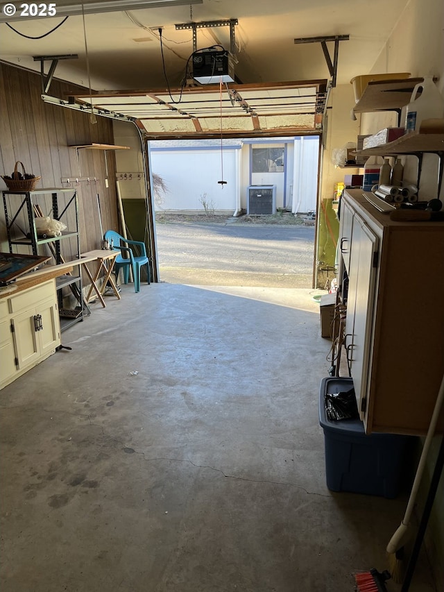 garage with a garage door opener and wooden walls