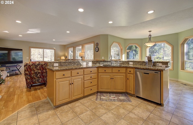 kitchen featuring a kitchen island with sink, a healthy amount of sunlight, and stainless steel dishwasher