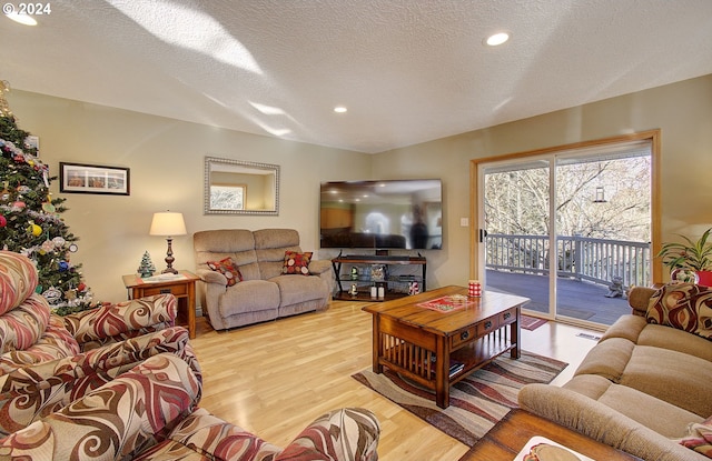 living room featuring a textured ceiling and light wood-type flooring