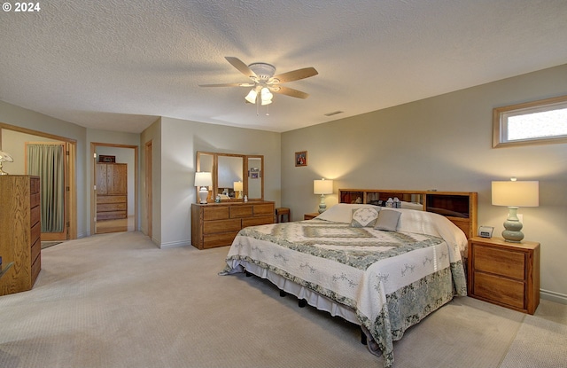 bedroom with light carpet, a textured ceiling, and ceiling fan