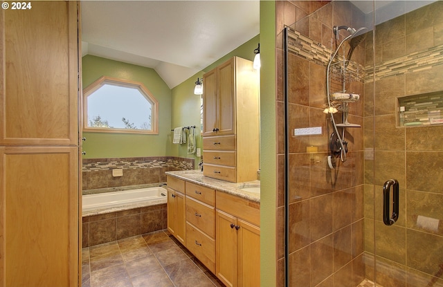 bathroom with tile patterned flooring, vanity, shower with separate bathtub, and vaulted ceiling