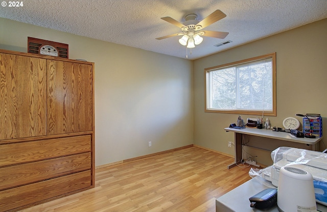 office area featuring a textured ceiling, light hardwood / wood-style flooring, and ceiling fan