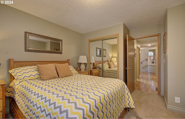 bedroom with carpet, a textured ceiling, and a closet