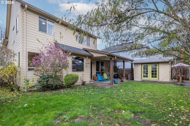 back of property with an outbuilding, a yard, and a patio