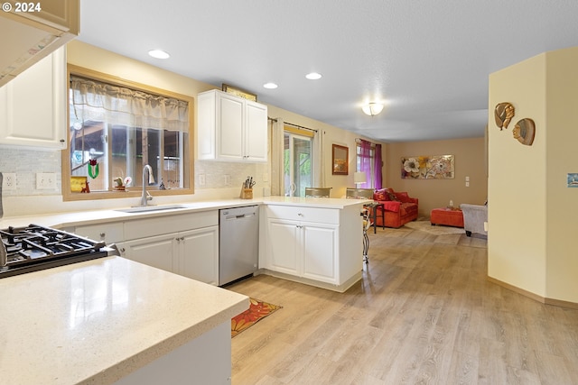 kitchen featuring white cabinets, backsplash, kitchen peninsula, dishwasher, and light wood-type flooring