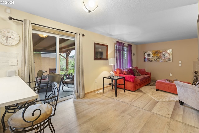 living room featuring light hardwood / wood-style flooring and a textured ceiling