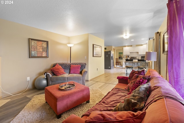 living room with light wood-type flooring and a textured ceiling