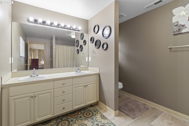 bathroom featuring vanity, toilet, and hardwood / wood-style flooring