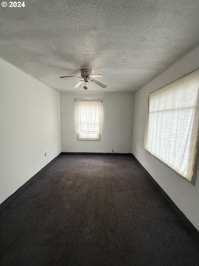 carpeted empty room featuring ceiling fan and a textured ceiling