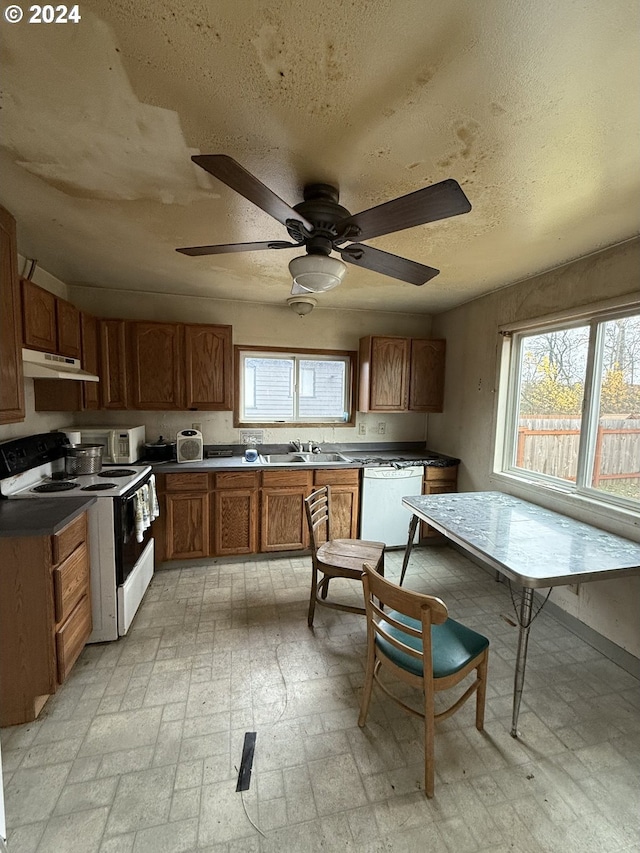 kitchen with ceiling fan, a healthy amount of sunlight, white appliances, and a textured ceiling