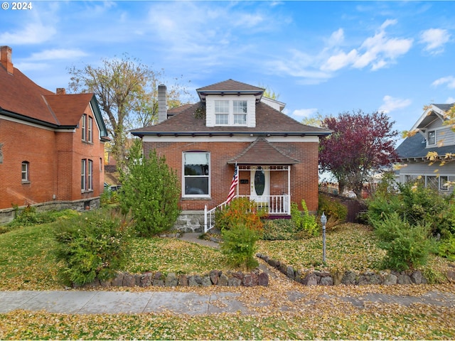 view of front of house featuring brick siding and a chimney