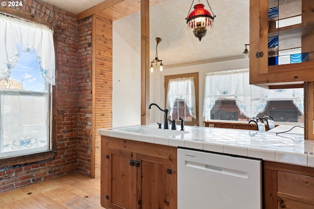 kitchen featuring tile counters, sink, white dishwasher, and light wood-type flooring