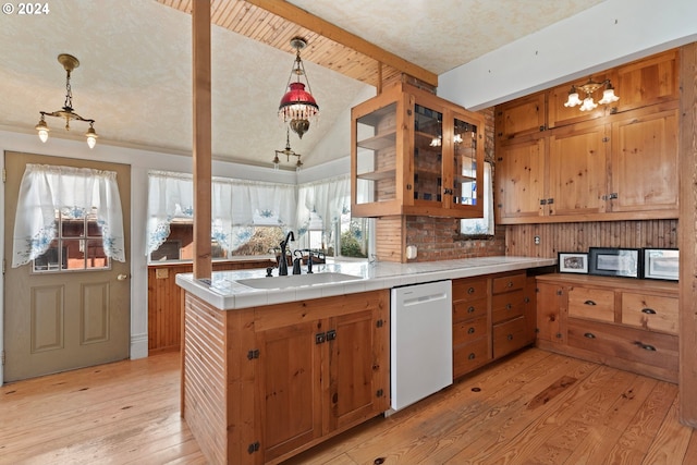 kitchen featuring sink, dishwasher, tile countertops, light hardwood / wood-style floors, and decorative light fixtures