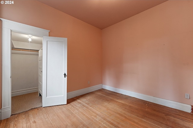 unfurnished bedroom with a closet and wood-type flooring