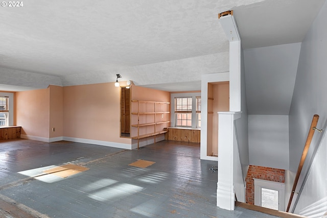 unfurnished living room with dark hardwood / wood-style floors and a textured ceiling