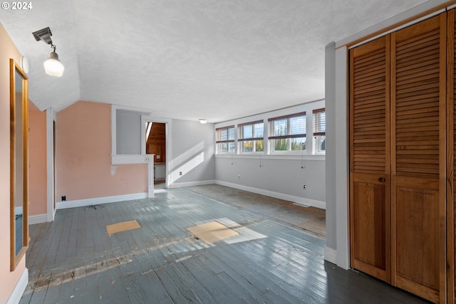 unfurnished living room featuring hardwood / wood-style flooring and vaulted ceiling