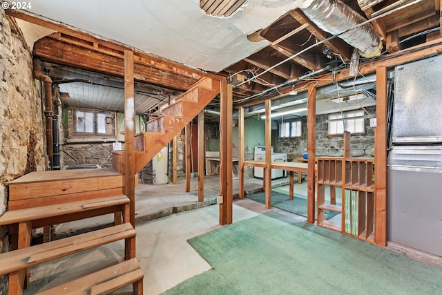 basement featuring washer / clothes dryer, a wealth of natural light, and gas water heater