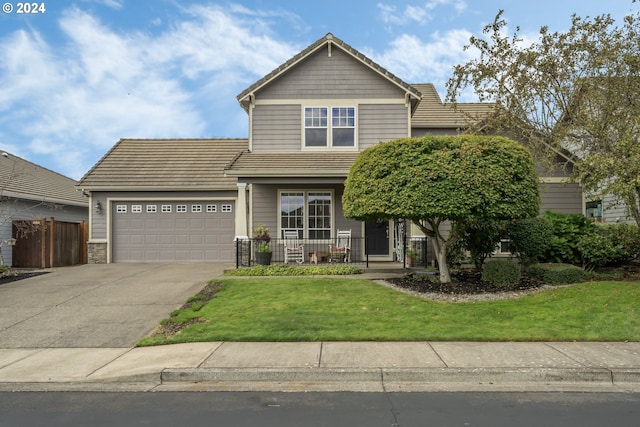 view of front of home featuring a front lawn, a porch, and a garage