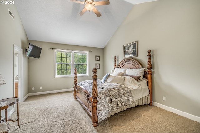 carpeted bedroom featuring lofted ceiling, ceiling fan, and ensuite bath