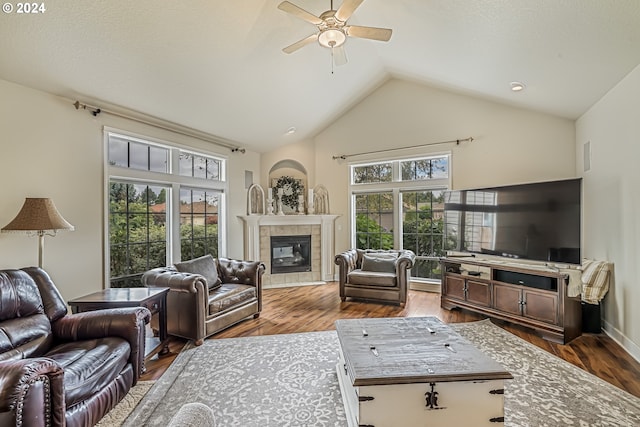 living room with a fireplace, dark hardwood / wood-style flooring, ceiling fan, and plenty of natural light