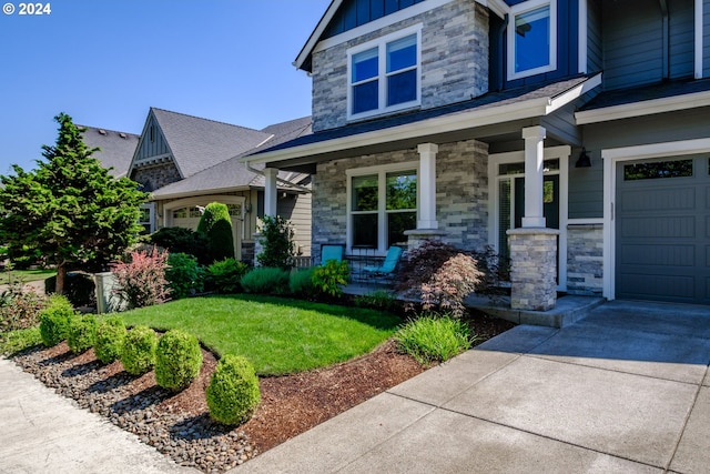 view of front of house with a garage, a front lawn, and a porch