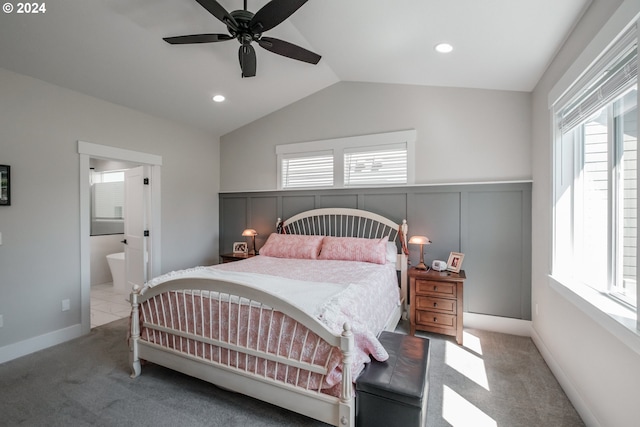 bedroom with vaulted ceiling, carpet flooring, ceiling fan, and ensuite bath