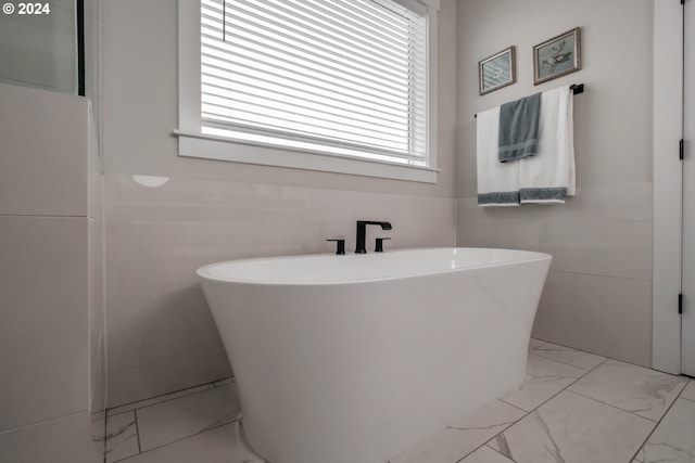 bathroom featuring tile walls and a tub