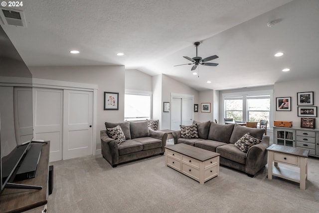 carpeted living room with vaulted ceiling, a textured ceiling, and ceiling fan