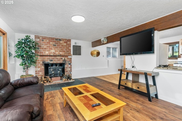 living room with a wood stove, a textured ceiling, and hardwood / wood-style flooring