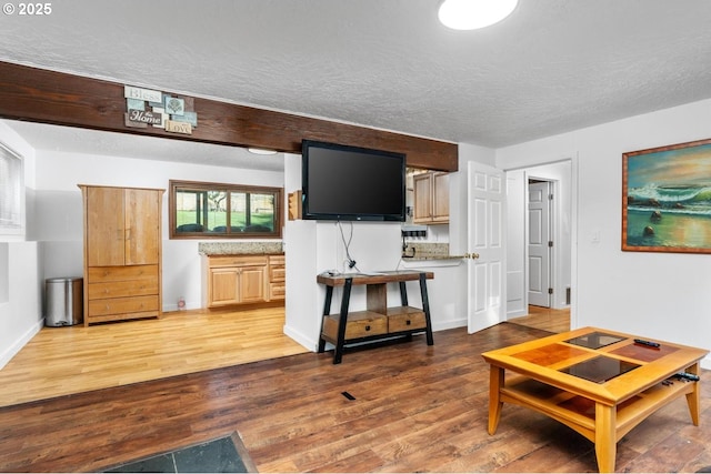 living room featuring a textured ceiling and dark hardwood / wood-style floors