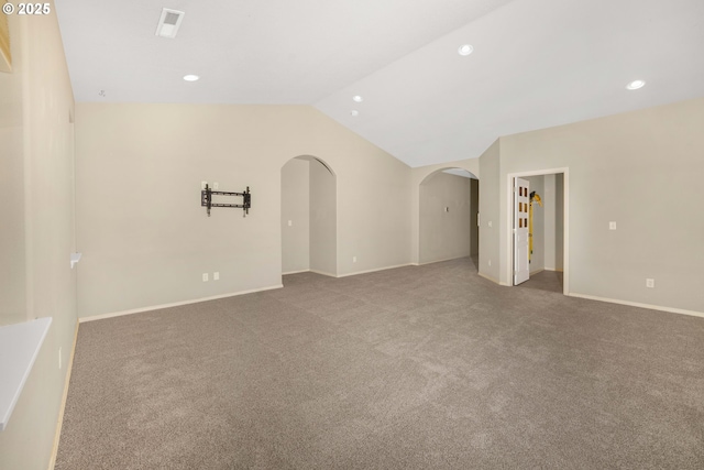 carpeted empty room with lofted ceiling, baseboards, arched walkways, and recessed lighting