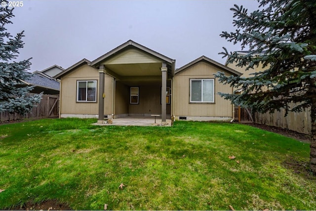 back of house featuring crawl space, a patio area, a lawn, and a fenced backyard