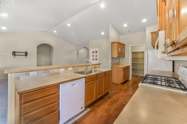 kitchen with white appliances, lofted ceiling, an island with sink, light countertops, and a sink