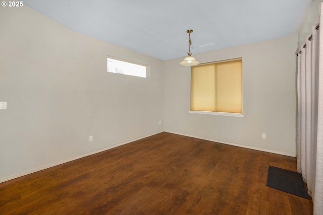 empty room featuring wood finished floors and baseboards