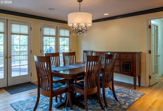 dining room featuring ornamental molding, a notable chandelier, french doors, and light hardwood / wood-style flooring