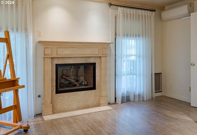 unfurnished living room featuring a wall mounted AC and light wood-type flooring