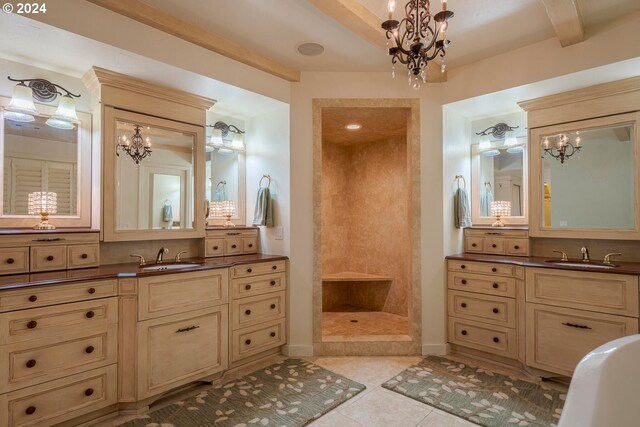 bathroom with a notable chandelier, tile patterned floors, walk in shower, and vanity