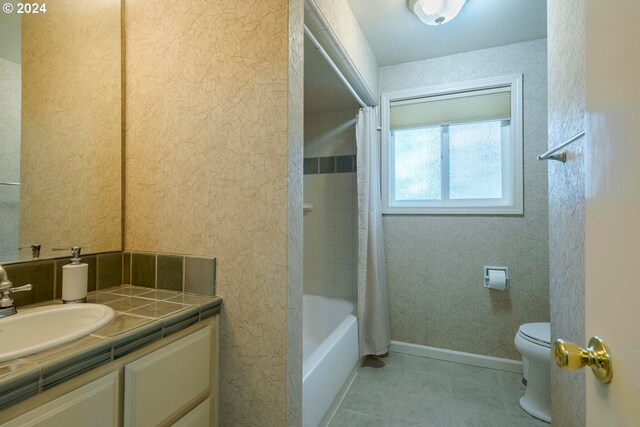 full bathroom featuring shower / bath combination with curtain, vanity, tile patterned flooring, and toilet