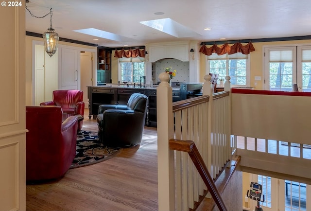 interior space with crown molding, a skylight, and hardwood / wood-style flooring