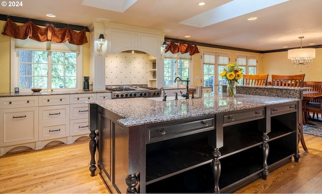 kitchen featuring sink, light hardwood / wood-style floors, a healthy amount of sunlight, and white cabinetry