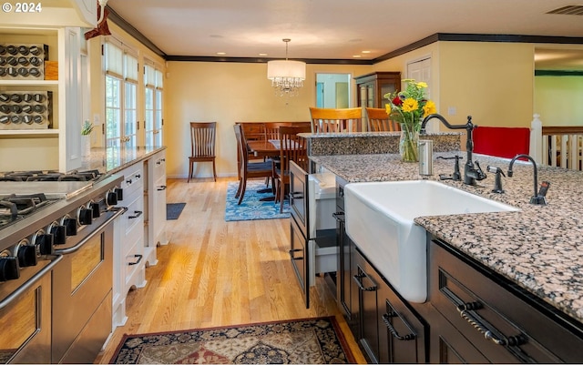 kitchen featuring light stone countertops, decorative light fixtures, light hardwood / wood-style flooring, and white cabinetry