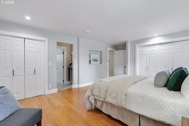 bedroom with multiple closets and hardwood / wood-style flooring