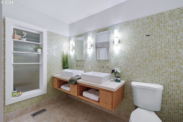 bathroom with tile walls, walk in shower, vanity, and toilet