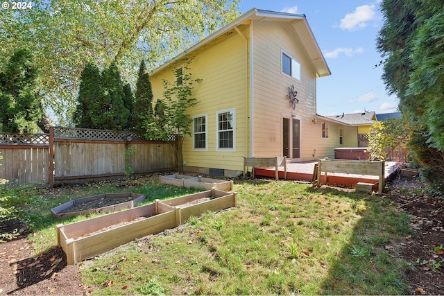 rear view of property with a deck and a lawn