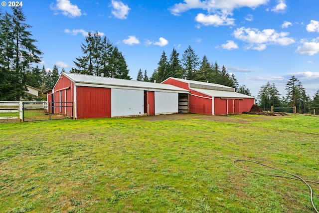 view of pole building with a lawn and fence