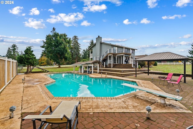 view of swimming pool featuring a gazebo, a diving board, and a patio