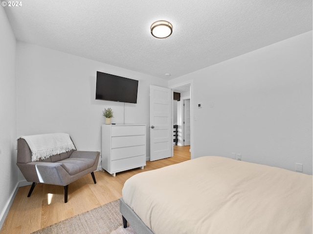 bedroom featuring a textured ceiling and light wood-type flooring