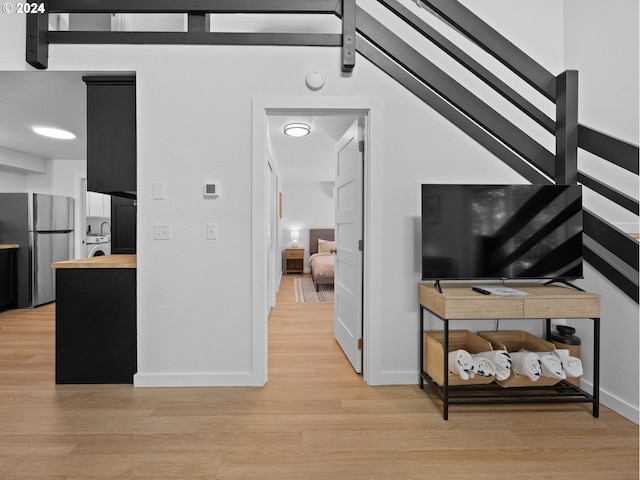 interior space featuring light hardwood / wood-style floors, lofted ceiling, and washer / dryer