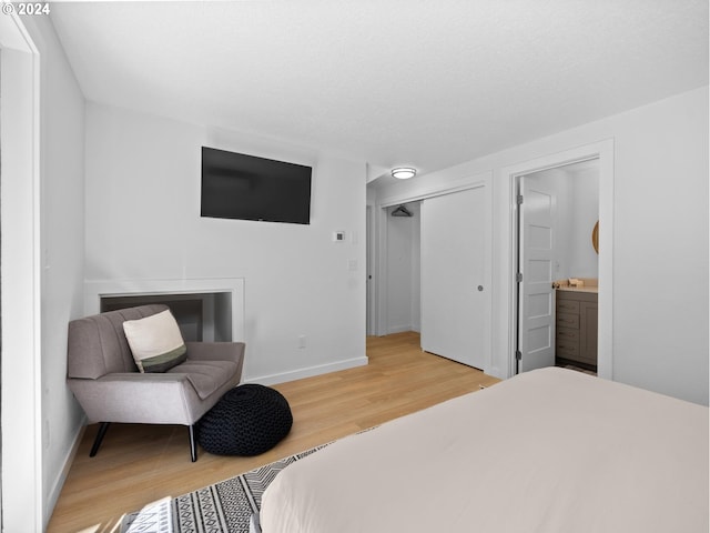 bedroom featuring ensuite bathroom and light hardwood / wood-style floors